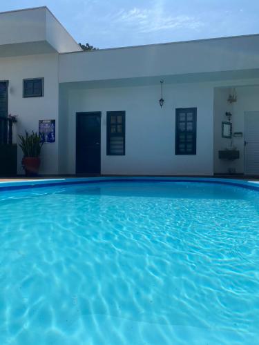 a swimming pool in a house with blue water at Pequeno Paraíso in Foz do Iguaçu