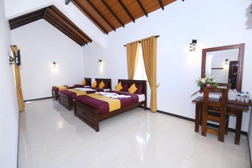 a bedroom with a bed and a table and a mirror at Queensland Hotel in Nuwara Eliya