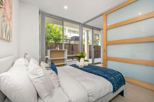a bedroom with a large white bed and large windows at Rose - The Fringe Escape in Bowden