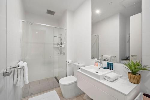 a white bathroom with a toilet and a sink at Rose - The Fringe Escape in Bowden