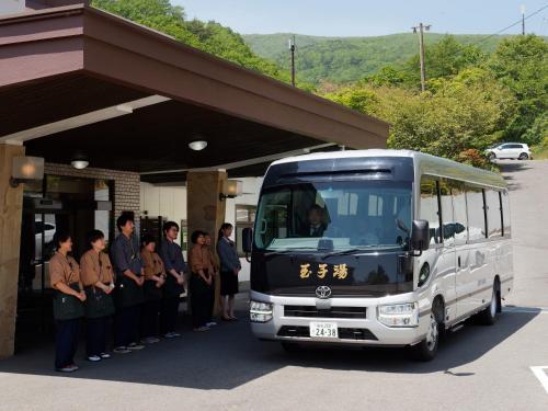 a group of people standing in front of a bus at Ryokan Tamagoyu in Machi-niwasaka