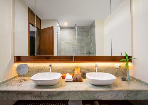 uma casa de banho com 2 lavatórios e um espelho em Angkor Grace Residence & Wellness Resort em Siem Reap