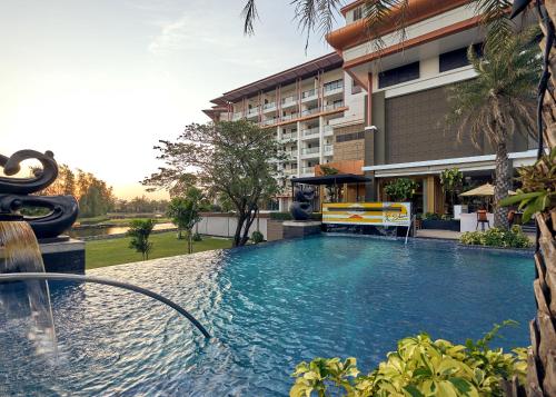 a swimming pool in front of a building at Le Meridien Suvarnabhumi, Bangkok Golf Resort and Spa in Bangkok