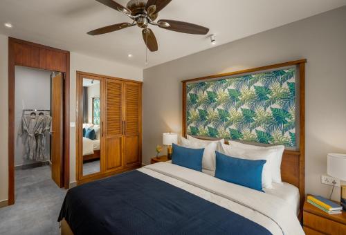 um quarto com uma cama grande e almofadas azuis em Angkor Grace Residence & Wellness Resort em Siem Reap