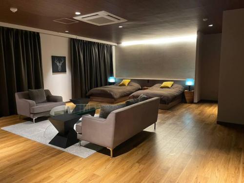Sala de estar con 2 sofás y mesa en 由楽 焼津 en Yaizu
