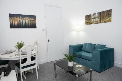 sala de estar con sofá azul y mesa en Shortridge Terrace - 1, en Jesmond