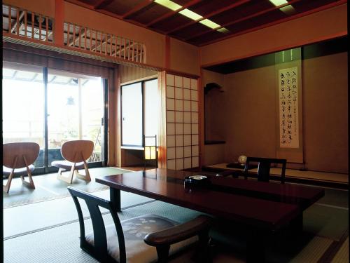 a room with a table and chairs in a room at Shin Kadoya in Atami