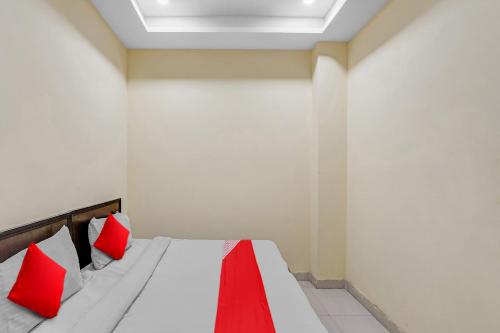 a bedroom with a bed with red pillows at Hotel O Mt Stays in Noida
