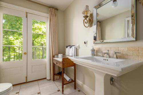 uma casa de banho com um lavatório e um espelho em The Old Bank House em Niagara-on-the-Lake