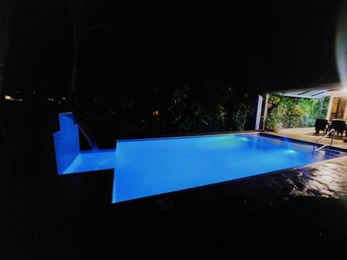 a swimming pool at night with a blue light at Golf Beach House w/ Pool (5 min. walk to beach!) in Tambor