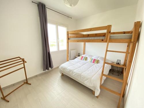 une chambre avec un lit superposé avec une échelle dans l'établissement Appartement Rénové Face à la Mer, 200m Plage de la Sauzaie, Balcons, Wifi, Parking à Proximité - FR-1-231-224, à Bretignolles-sur-Mer