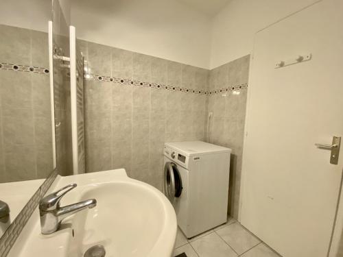 une salle de bain avec un lavabo et une machine à laver dans l'établissement Appartement Rénové Face à la Mer, 200m Plage de la Sauzaie, Balcons, Wifi, Parking à Proximité - FR-1-231-224, à Bretignolles-sur-Mer