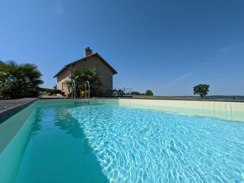 une grande piscine avec une maison en arrière-plan dans l'établissement Maison isolée avec piscine privée et spa, Charente - FR-1-653-4, à Montignac-le-Coq