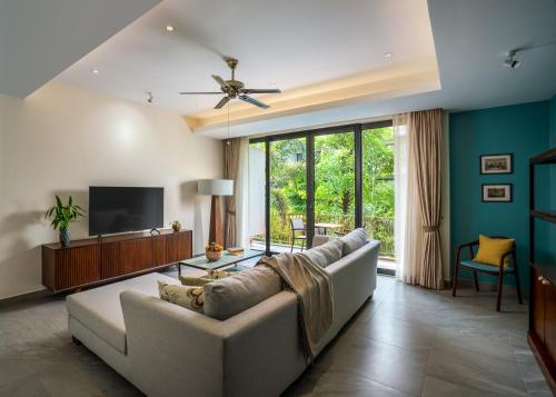 a living room with a couch and a tv at Angkor Grace Residence & Wellness Resort in Siem Reap