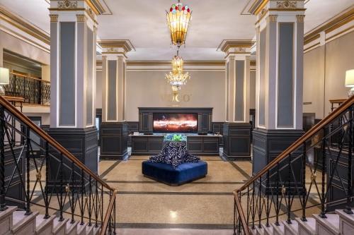a lobby with a fireplace and a blue couch at voco The Tiger Hotel, Columbia, MO by IHG in Columbia