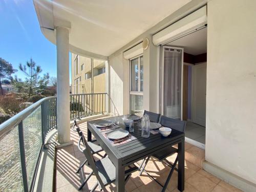 une table noire et des chaises sur un balcon dans l'établissement Appartement 2 pers. rénové avec balcon, accès plage et centre-ville à pied - Classé 2* - FR-1-231-285, à Bretignolles-sur-Mer