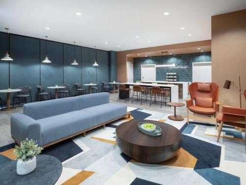 a lobby with a couch and a table and chairs at Staybridge Suites Chicago O'Hare - Rosemont by IHG in Rosemont