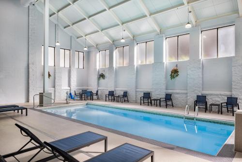 a swimming pool with chairs and tables in a building at Graystone Lodge, an Ascend Collection Hotel in Boone