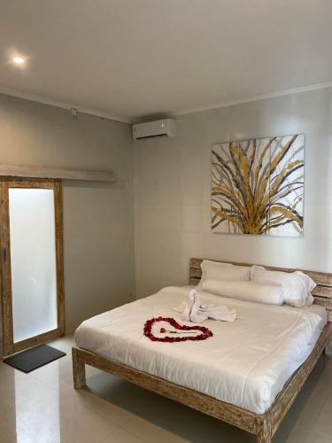 a bedroom with a large bed with white sheets at Moonshine Villa in Seminyak