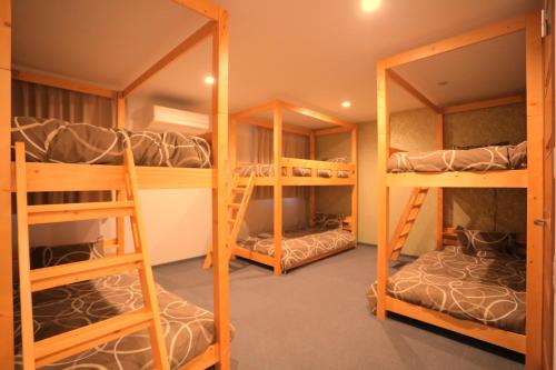 a room with three bunk beds in a room at 遊悠館 in Chitose