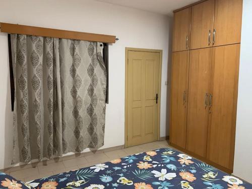 1 dormitorio con cama, armario y puerta en 2 Bedroom @ Devtraco Estates -Tema Comm 25, en Tema