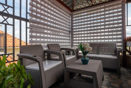 a patio with wicker chairs and a vase of flowers at Loft con terraza en Santo Domingo in La Estrella