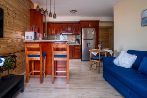 a living room with a blue couch and a kitchen at Loft con terraza en Santo Domingo in La Estrella