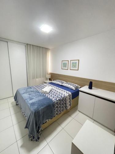 a bedroom with a bed with a blue comforter at Iloa Residence Ap 103 K Barra de São Miguel AL in Barra de São Miguel