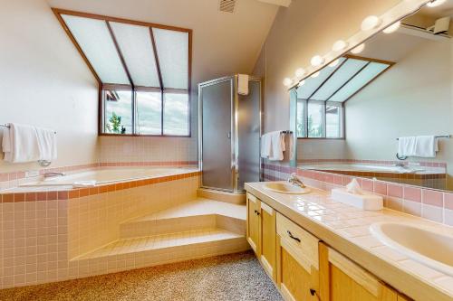 a bathroom with two sinks and a shower and a tub at River Edge Retreat in Redmond