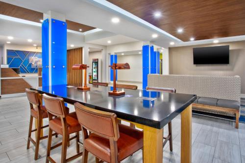 a dining room with a table and chairs at Holiday Inn Express Hotel and Suites Katy by IHG in Katy