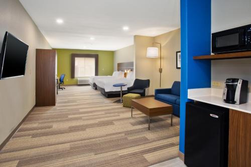 a hotel room with a bed and a living room at Holiday Inn Express Hotel and Suites Katy by IHG in Katy