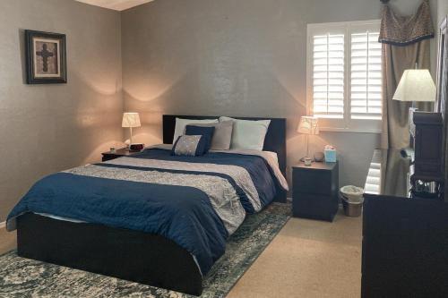 a bedroom with a large bed with blue sheets and pillows at Good Memories in Goodyear in Goodyear