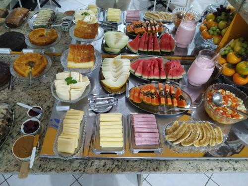 einem Tisch mit vielen verschiedenen Lebensmitteln in der Unterkunft Hotel Barril in Primavera do Leste