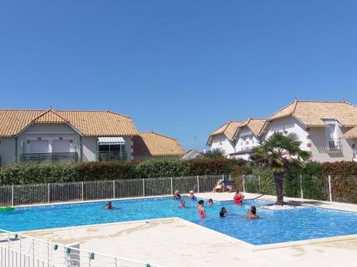 - un groupe de personnes dans la piscine d'un complexe dans l'établissement Maison 40m² avec piscine, WiFi et jardin privé – Idéale pour 4 personnes à Notre-Dame-de-Monts - FR-1-540-145, à Notre-Dame-de-Monts