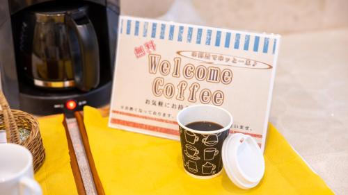 a cup of coffee on a yellow napkin with a book at Hotel Dorf Shizuoka in Shizuoka