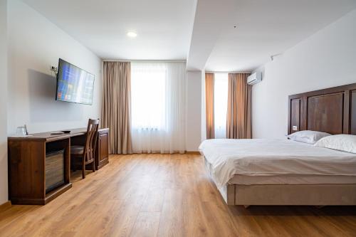 ein Schlafzimmer mit einem Bett und einem Schreibtisch mit einem Computer in der Unterkunft Voyager in Mamaia Nord – Năvodari