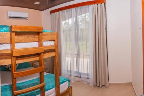 a bedroom with two bunk beds and a window at Villa Aurora with Jacuzzi in La Fortuna in Fortuna