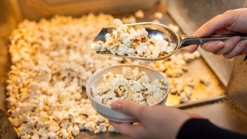 a person holding a bowl of popcorn and two spoons at Hotel Dorf Shizuoka in Shizuoka