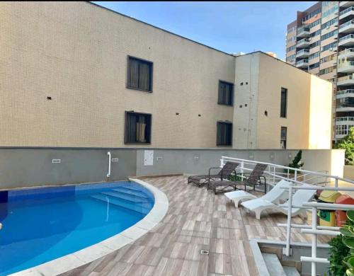 a patio with a swimming pool and a building at Atlântico Vista Mar Deluxe in Fortaleza