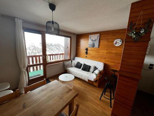a living room with a couch and a table at Appartement BELLE PLAGNE et PARKING in Belle Plagne