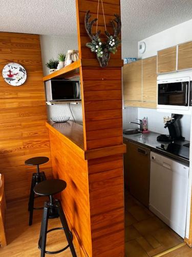 - une cuisine avec un comptoir et deux tabourets dans l'établissement Appartement BELLE PLAGNE et PARKING, à Belle Plagne