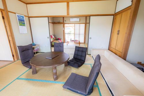 ein Wohnzimmer mit einem Tisch und Stühlen in der Unterkunft Goto I-House in Goto