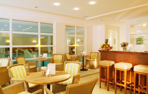 a restaurant with tables and chairs and windows at Hotel Birke, Ringhotel Kiel in Kiel