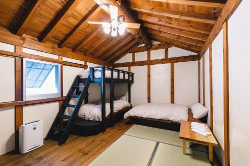 two bunk beds in a room with a ceiling at 1組貸切りの宿 Thank you Hippo 2 -KURA 蔵- in Matsumoto
