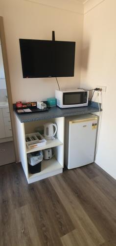 a microwave sitting on top of a counter next to a refrigerator at Burketown Pub in Burketown