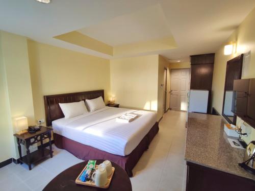 a hotel room with a bed and a television at The Chanthong Residence and Hotel Pattaya in Pattaya South