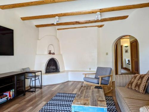 uma sala de estar com um sofá e uma lareira em Adorable Adobe Taos - excellent location between ski valley and town! em El Prado