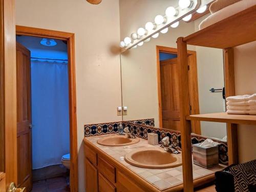 uma casa de banho com 2 lavatórios e um espelho grande em Adorable Adobe Taos - excellent location between ski valley and town! em El Prado
