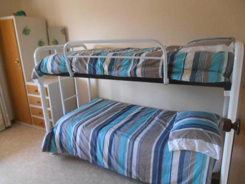 a bedroom with two bunk beds in a room at Ebb N Flow Beach House - Stansbury in Stansbury