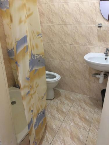 La salle de bains est pourvue de toilettes et d'un lavabo. dans l'établissement Номера та Паркінг- Rooms & Parking, à Tchernivtsi